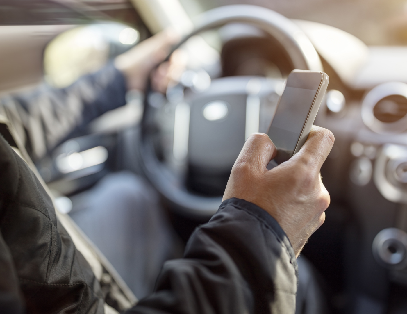 Man driving while distracted by phone